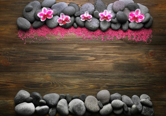Spa stones and orchid on wooden background