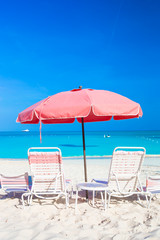 Fototapeta na wymiar Beach chairs on exotic tropical white sandy beach