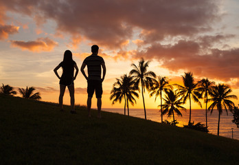 Romantic couple enjoying beautiful sunset in Hawaii
