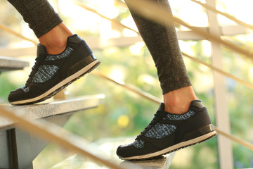 Sports woman legs in sneakers on stairs