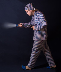 man in pajamas walking around with a gun