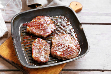 Roasted beef fillet on pan, on wooden background