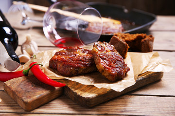 Roasted beef fillet and vegetables on cutting board, on wooden background