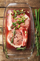 Marinating meat with spices on wooden table