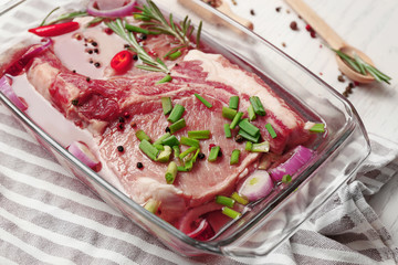 Marinating meat with spices on table, close up