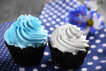 Chocolate cupcakes and flowers on napkin, closeup