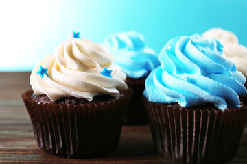 Chocolate cupcakes on wooden table in front of blue background
