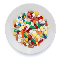 Pills, capsules and tablets on white plate