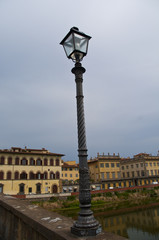 Fototapeta na wymiar Glowing vintage street lamp on background with Arno river Firenze , italy