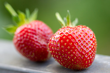 Closeup of two fresh strawberries, one of them intentionally blurred in low depth of field