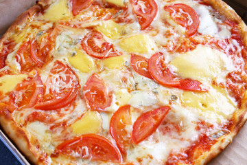 Delicious full of cheese pizza with tomatoes background