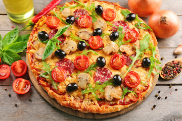 Delicious tasty pizza with ingredients on wooden table