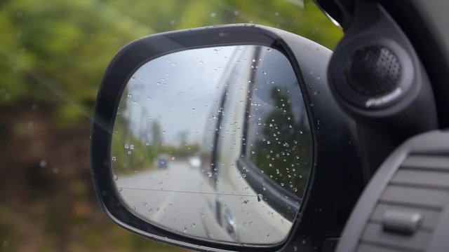 Driving in Rain. Side Mirror of Car.