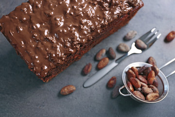 Delicious chocolate cake with nut cream on grey background, close up
