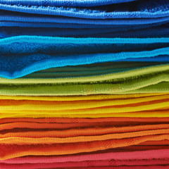 Pile of rainbow colored towels isolated