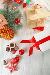 Christmas background. Decorations, cones, gift boxes on white wooden background