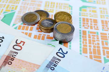 Euro coins and banknotes on map background