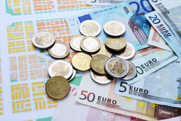 Euro coins and banknotes on map background