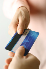 Hands holding blue credit card on white background