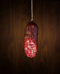 a piece salami sausages on a wooden background