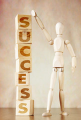 Man achieves success. Conceptual image with wooden dummy