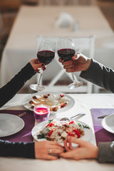 Two people toasting with wine glasses. young couple drinking red wine at bar