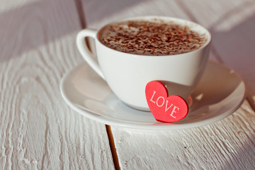 Beautiful coffee Cup with heart on a white wooden background