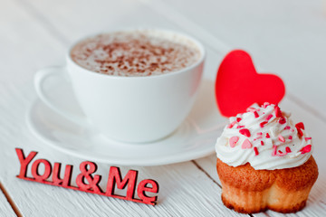 Beautiful coffee Cup with heart cupcake on white wooden background