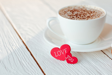 Beautiful coffee Cup with heart on a white wooden background