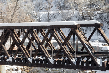 Snow covered wooden railway bridge over the Animas river