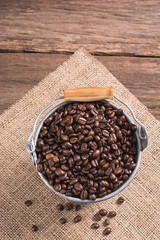 coffee beans in zinc bucket on wooden background/cloth sack