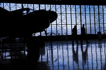 Silhouette prop airplane in hanger with two mechanics 