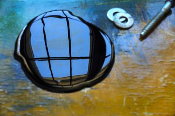 Oil spill on orange and blue work table with window reflection 