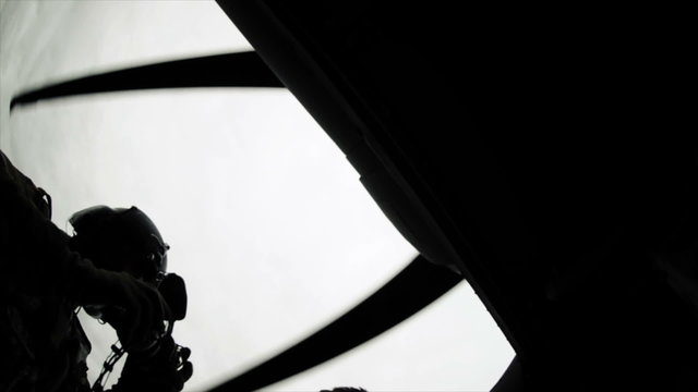 Upward pointing shot of guys exiting Black Hawk helicopter.