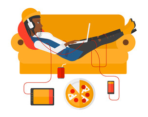 Woman with gadgets lying on sofa