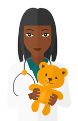 Pediatrician holding teddy bear.