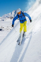 Skier skiing downhill in high mountains