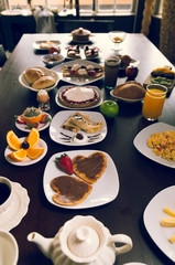  Elegant breakfast buffet selection spread out over large table, shot from short end of long table