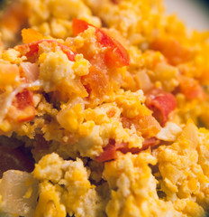 Closeup of delicious scrambled eggs with ham and vegetables mixed