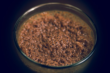 Cloeseup glass of cold coffee drink with brown foamy topping