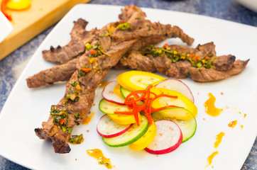Delicious twisted sirloin cuts with vegetables placed on white plate, elegant presentation