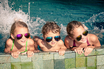 happy children  playing on the swimming pool at the day time