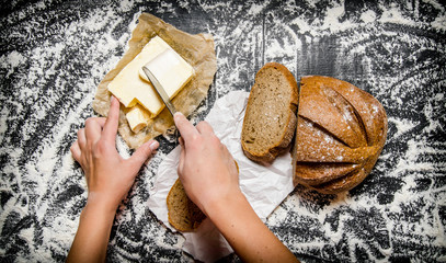The buttering of bread with butter on Board with flour.
