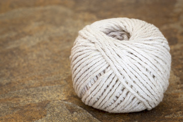 Ball of White String or Twine on Stone Background