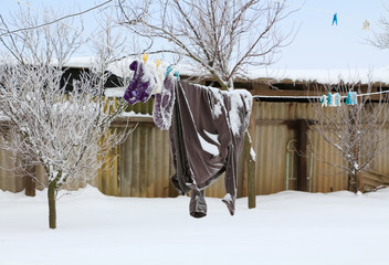 Clothes dried on a rope on a poor rural winter background