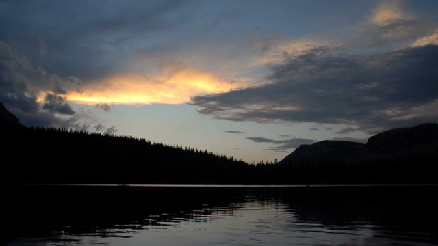 Time-lapse of a mountain lake and clouds at sunset.