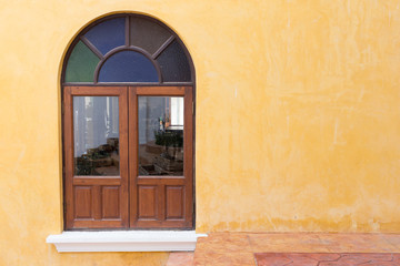 Fototapeta na wymiar wood window on yellow cement mortar wall background