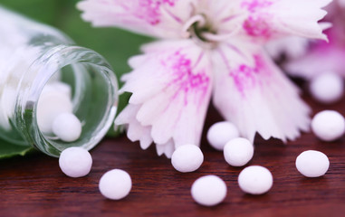 Obraz na płótnie Canvas Homeopathy globules with herbal flower