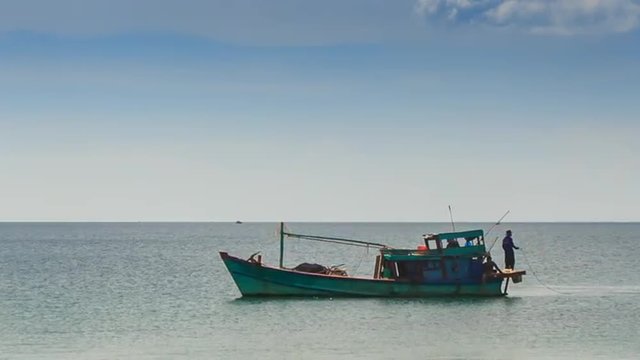 Vietnamese Fishing Boat Man on Stern Drifts along Sea