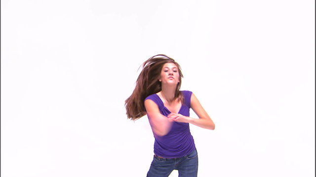 Girl in a purple shirt and jeans dancing.